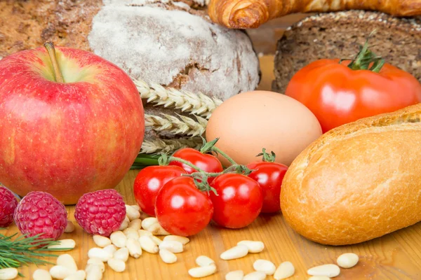 Mesa de la cocina con una gran cantidad de alimentos como pan y verduras — Foto de Stock