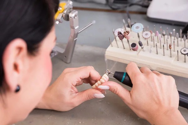 Technicien au travail dans un laboratoire dentaire ou un atelier produisant une prothèse — Photo