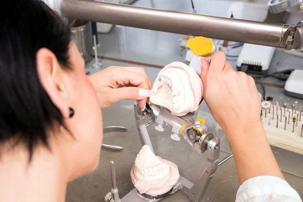 Un técnico dental que trabaja en un molde en un laboratorio — Foto de Stock