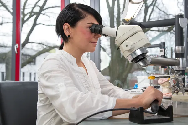 Technicus in een tandheelkundige lab of workshop werken onder een Microscoop — Stockfoto