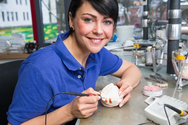 Technicien dentaire appliquant de la cire sur un moule pour produire une prothèse — Photo