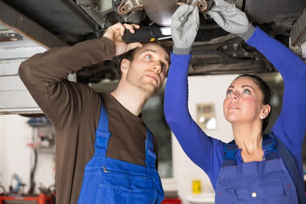 Twee mechanica herstellen van een auto in hydraulische lift — Stockfoto