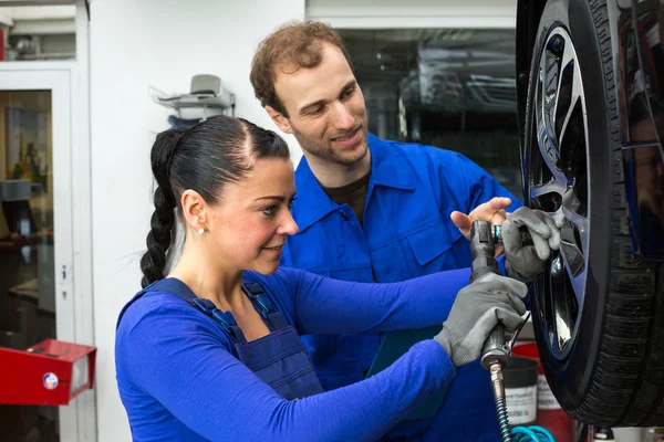 Mechanika samochodowego, zmiana koła działa na Podnośnik hydrauliczny — Zdjęcie stockowe