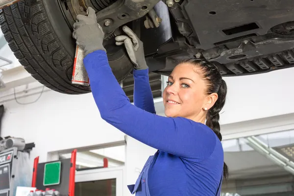 Mechanics repairing a car on hydraulic ramp — Stock Photo, Image