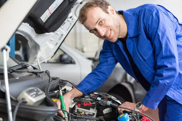 Mechanic repairing a car in a workshop or garage — Stock Photo, Image