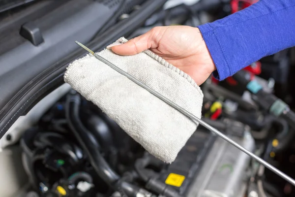 Mechanik samochodowy, przyjrzenie się poziom oleju — Zdjęcie stockowe