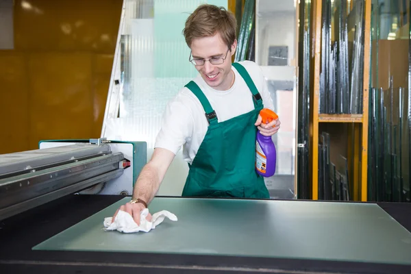 Worker in glazier's workshop cleaning a glass — Stock Photo, Image