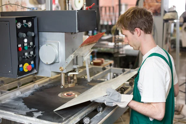 Worker operates glass drilling machine — Stock Photo, Image