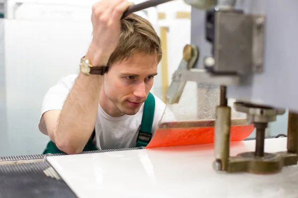 Worker operates glass drilling machine — Stock Photo, Image