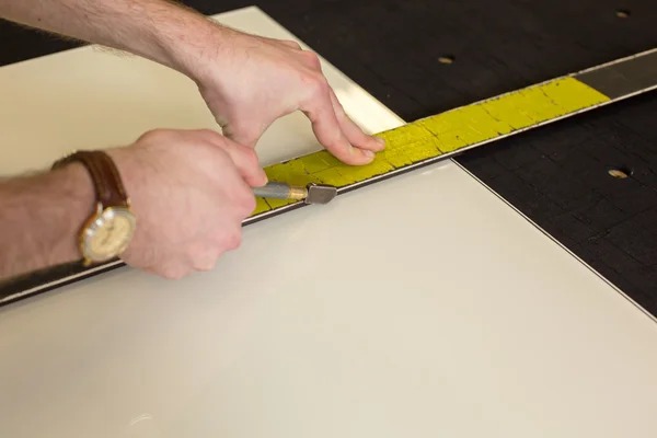 Glazier in workshop cutting glass — Stock Photo, Image