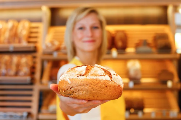 Piekarnia sprzedawczyni z bochenka chleba — Zdjęcie stockowe