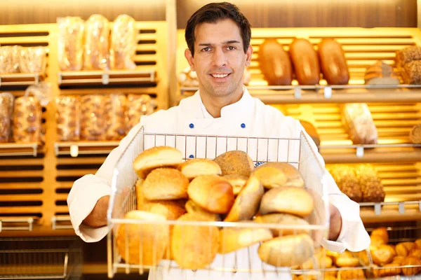 Shopkeeper med korg med bröd — Stockfoto