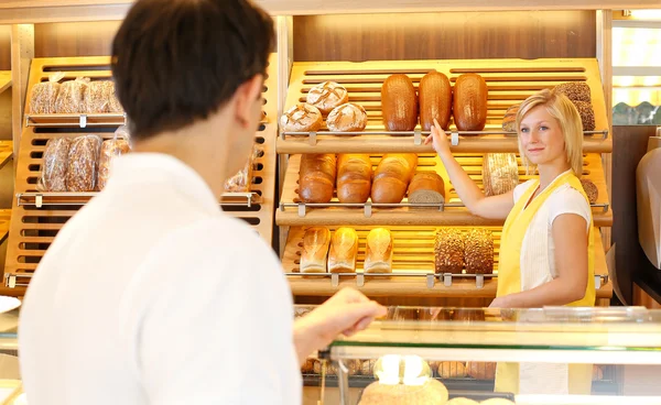 Commerçant dans la boulangerie avec client — Photo