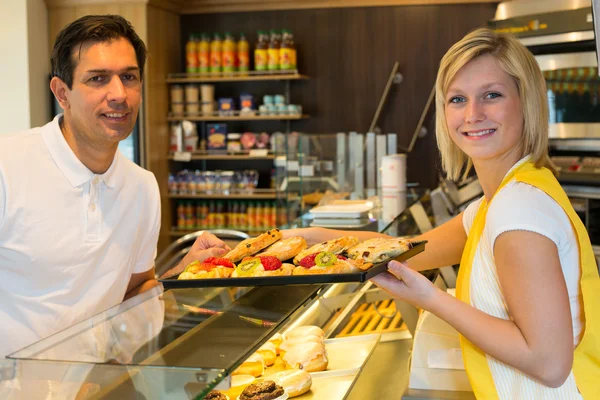 Shopkeeper giving pastry to customer — Stock Photo, Image