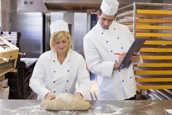 Instructor instructing an apprentice in bakery — Stock Photo, Image