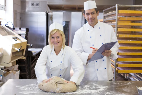 Instructor instructing an apprentice in bakery — Stock Photo, Image