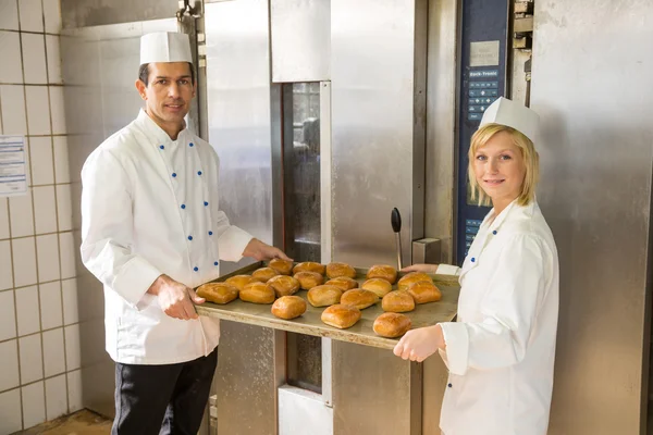 Bagare med tablett bröd i bageriet eller bakehouse — Stockfoto