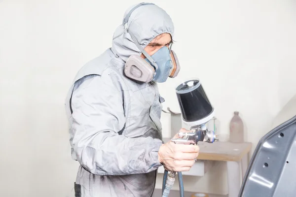 Pintor de corpo de carro pulverizando tinta em partes da carroçaria — Fotografia de Stock