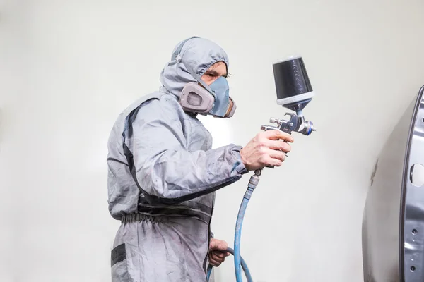 Car body painter spraying paint on bodywork parts — Stock Photo, Image