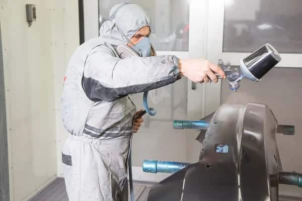 Pintor de corpo de carro pulverizando tinta em partes da carroçaria — Fotografia de Stock