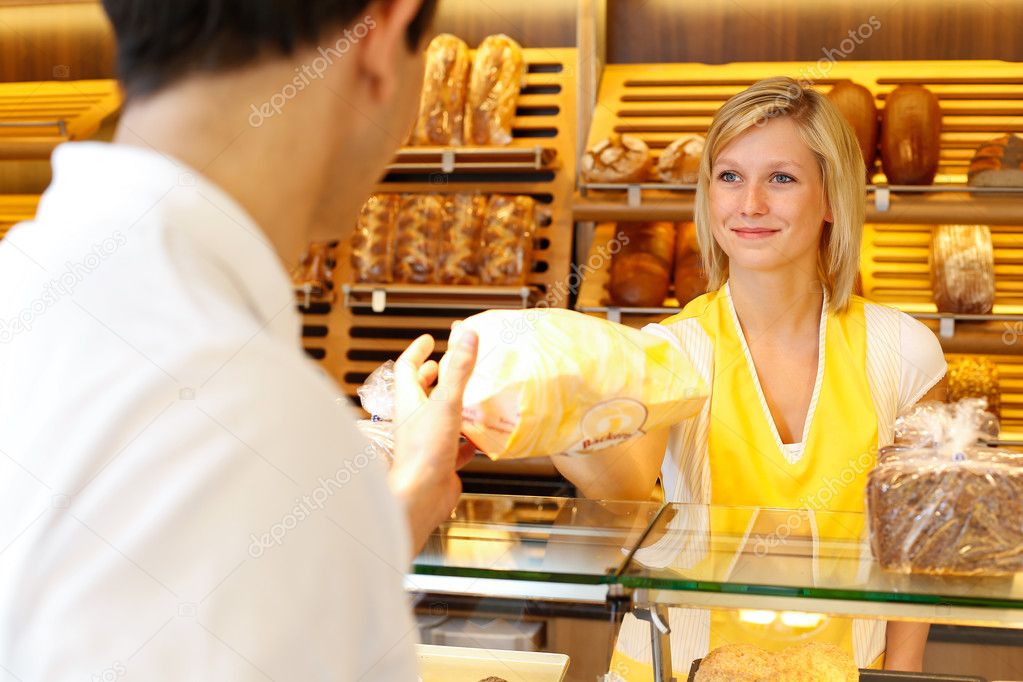 Baker's shop shopkeeper gives bread to customer