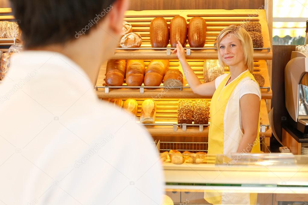Shopkeeper in baker's shop with customer
