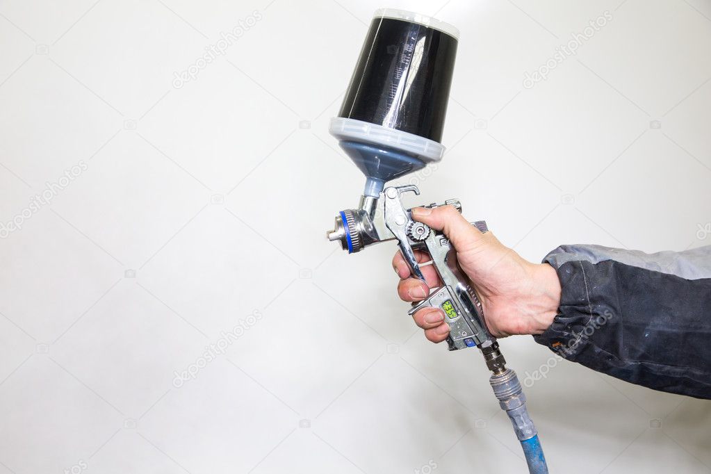 Car body painter spraying paint on bodywork parts Stock Photo by