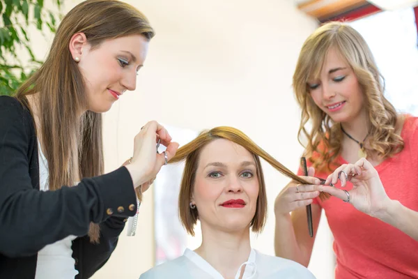 Перукарні, що ріжуть волосся клієнтів в салоні — стокове фото