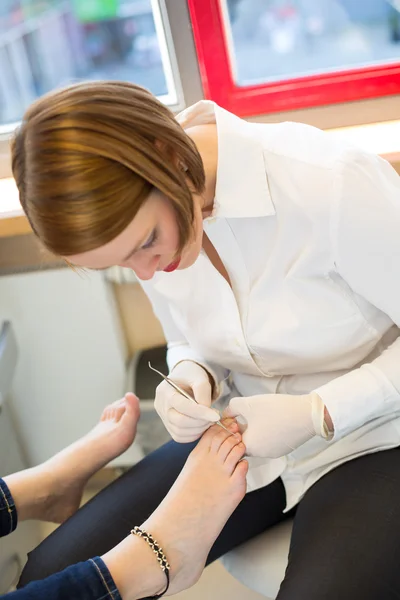 Pedicure caring for clients foot nails — Stock Photo, Image