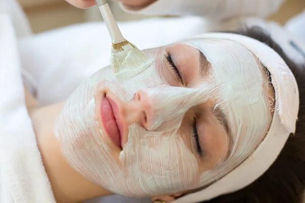 Kosmetikerin gibt Kunden Gesichtspflegemaske — Stockfoto