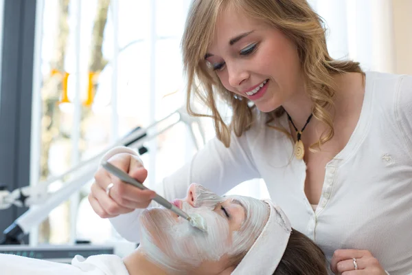 Cosmetician dando máscara facial cliente de cuidados com a pele — Fotografia de Stock