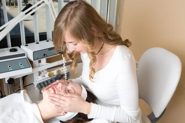 Cosmetician giving customer face massage — Stock Photo, Image