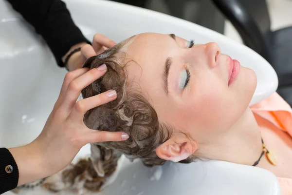 Hairstylist washing customers hair — ストック写真