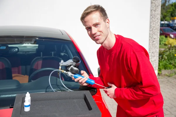 Glazier repairing windscreen after stone chipping damage — Stock Photo, Image