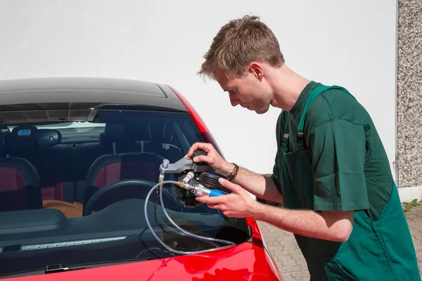 Glazier repairing windscreen after stone chipping damage — Stock Photo, Image