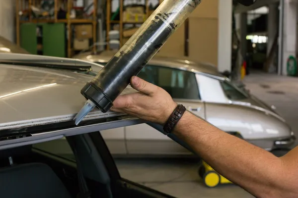 Glazier con pistola de aplicación para aplicar adhesivo para parabrisas — Foto de Stock