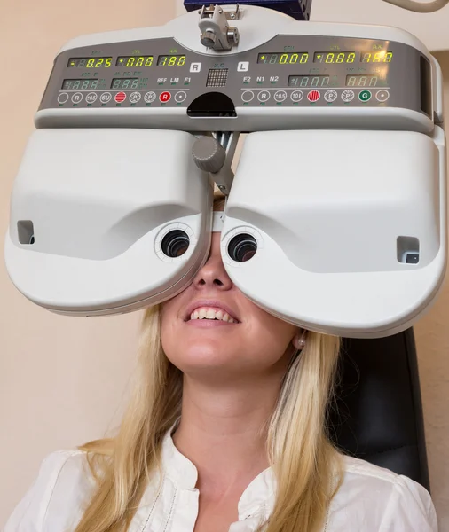 Customer of a optometrist or optician looking through phoropter — Stock Photo, Image