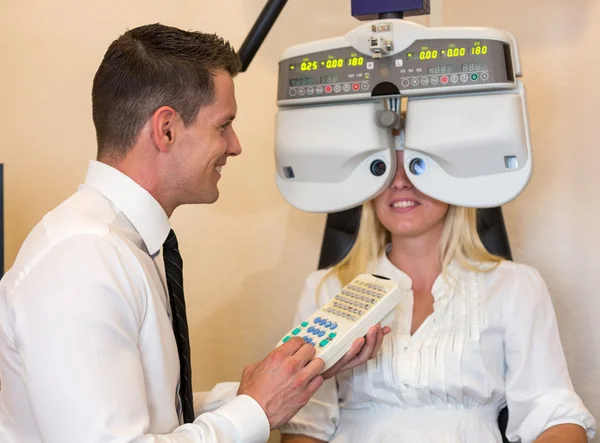 Optician or optometrist and patient with a phoropter — Stock Photo, Image