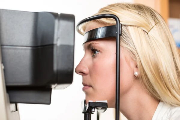 Patient and auto refractometer at optician or optometrist — Stock Photo, Image