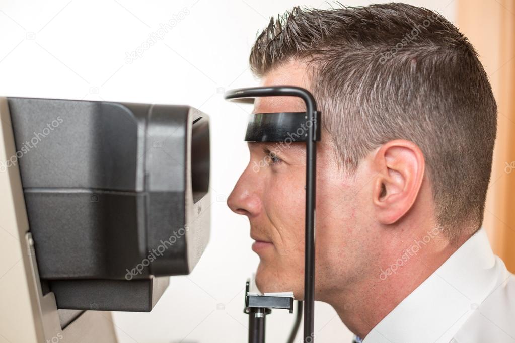 Patient and auto refractometer at optician or optometrist