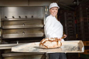 fırıncı fırıncılık içinde ekmek kabuğu üzerinde sunuyor.