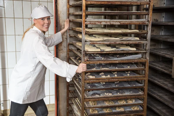 Baker náplň trouba v pekařství nebo pekárna — Stock fotografie