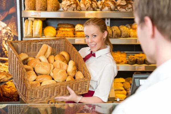 Panadero en panadería con canasta llena de pan — Foto de Stock