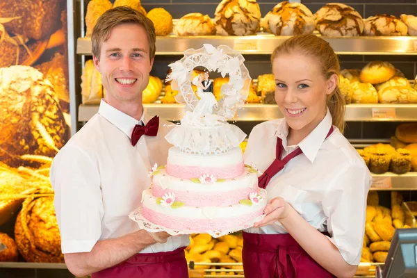 Baker with wedding cake in confectionery — Stock Photo, Image