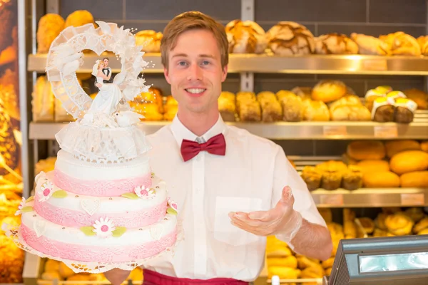 Padeiro com bolo de casamento em confeitaria — Fotografia de Stock