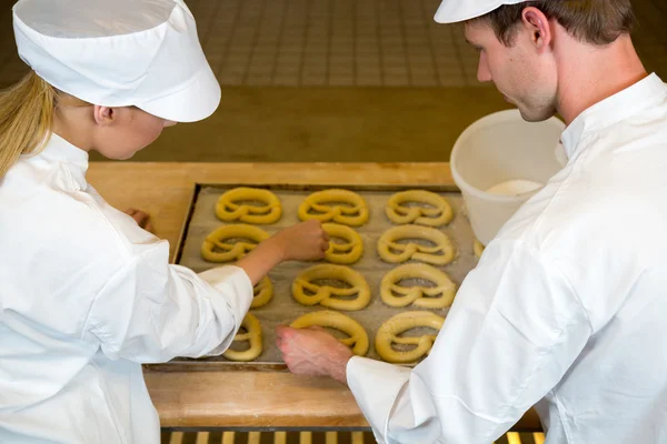 Panettieri in panetteria che producono pretzel — Foto Stock