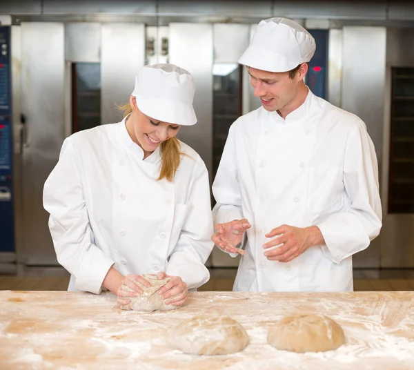 Instructeur et apprenti boulanger pétrissant la pâte à pain — Photo