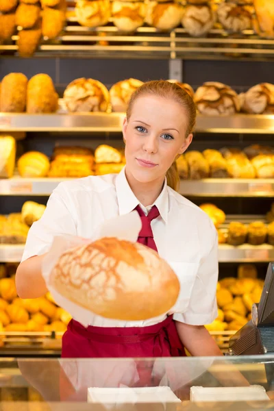 Shopkeeper en Panadería dando pan al cliente — Foto de Stock