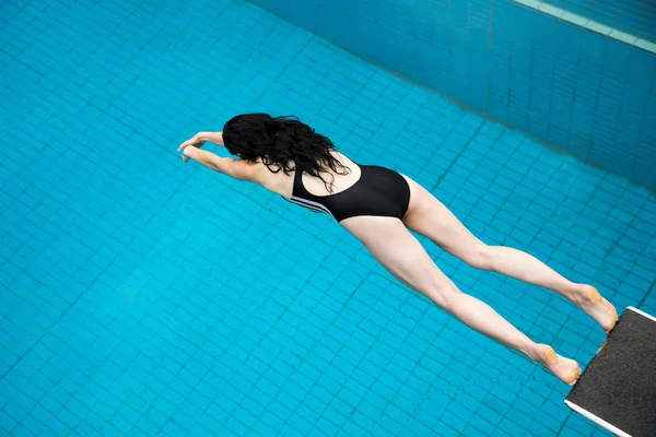Mulher salta de uma prancha de primavera na piscina — Fotografia de Stock