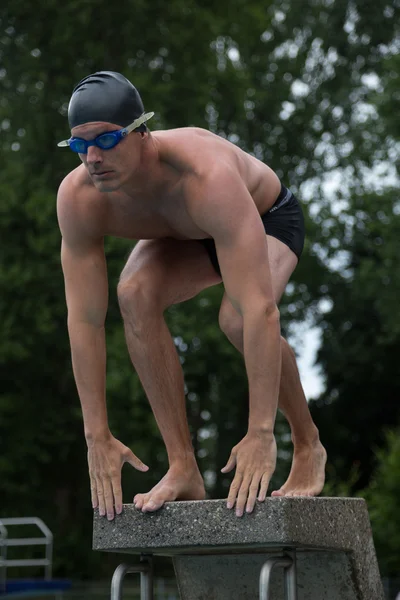 Nageur debout sur le bloc de départ à la piscine — Photo